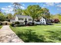 Expansive front lawn and well-maintained home exterior featuring lush landscaping and a detached garage at 3916 Riverbend Rd, Charlotte, NC 28210