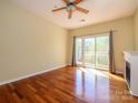A bright bedroom featuring hardwood floors, ceiling fan, and sliding glass door to balcony at 535 Donatello Ave, Charlotte, NC 28205