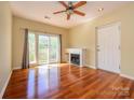 A bright living room featuring hardwood floors, ceiling fan, and sliding glass door to balcony at 535 Donatello Ave, Charlotte, NC 28205