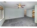 Open living room featuring neutral carpet, a ceiling fan, and a window bringing in natural light at 6005 Fringe Tree Dr, Charlotte, NC 28227