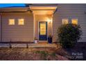 Inviting front entrance with stylish door, plants, and decorative lighting at 6619 Portland Rose Ln, Charlotte, NC 28210