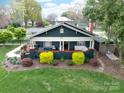 An aerial view of the home showcasing its cozy front porch, complemented by a lush lawn and landscaping at 803 Catawba St, Belmont, NC 28012
