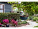 Close-up of landscaped front yard, displaying vibrant flowers, manicured bushes, and welcoming walkway to porch at 803 Catawba St, Belmont, NC 28012