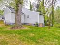 View of the backyard showing the home's exterior, grassy lawn and surrounding trees at 809 N Ransom St, Gastonia, NC 28052