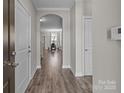 Inviting hallway with hardwood floors leads to an arched entry to the dining area at 9087 Treetop Nw Way, Concord, NC 28027