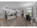 Open kitchen and dining area with stainless steel appliances and hardwood flooring at 9087 Treetop Nw Way, Concord, NC 28027