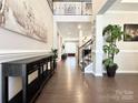 Grand foyer with hardwood floors, staircase, console table and decor, offering a welcoming entrance at 9677 Garamont Nw Pkwy, Concord, NC 28027