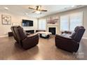 Comfortable living room with hardwood floors, fireplace, TV, and cozy reclining chairs at 9677 Garamont Nw Pkwy, Concord, NC 28027