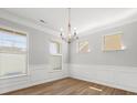 Dining room features chair rail molding, hardwood floors, and three large windows that provide natural light at 110 Lantern Acres Dr, Mooresville, NC 28115