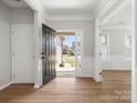 Bright foyer with wood flooring, white wainscoting, and an open view of the home's front exterior at 110 Lantern Acres Dr, Mooresville, NC 28115