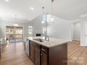 Open kitchen with island sink and stainless steel dishwasher overlooks the fireplace and backyard at 110 Lantern Acres Dr, Mooresville, NC 28115