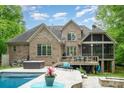 Expansive backyard featuring a pool, hot tub, deck, and screened porch offering luxurious outdoor living at 112 Spring Branch Rd, Fort Mill, SC 29715