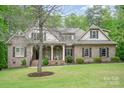 Charming brick home featuring a covered porch, manicured lawn, and mature trees enhancing curb appeal at 112 Spring Branch Rd, Fort Mill, SC 29715