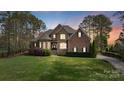 Charming two-story brick and stone home with lush landscaping and a well-manicured lawn at 116 Whispering Cove Ct, Mooresville, NC 28117