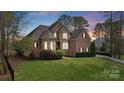 Charming two-story brick and stone home with lush landscaping and a well-manicured lawn at 116 Whispering Cove Ct, Mooresville, NC 28117
