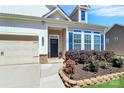 Inviting front entrance with blue door, neatly landscaped garden, and well-maintained lawn at 1224 Horsesugar Rd, Clover, SC 29710