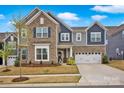 Inviting two-story home featuring a combination of stone and siding and an attached two-car garage at 14921 Baldridge Dr, Huntersville, NC 28078