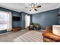 Cozy living room with blue walls, plush carpet, a ceiling fan, and natural light from the windows at 14921 Baldridge Dr, Huntersville, NC 28078
