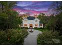 Serene view of a stately home with a water fountain and perfectly manicured landscaping at dusk at 200 Highland Forest Dr, Charlotte, NC 28270