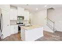 Stylish kitchen with white cabinets, stainless steel appliances and a granite topped island at 2060 Old Rivers Rd, Concord, NC 28027