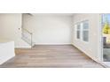 Open living area with modern flooring, neutral walls, large windows and staircase at 2060 Old Rivers Rd, Concord, NC 28027