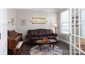Inviting living room featuring a leather couch, hardwood floors, and natural light at 2097 Saddlebred Dr, Iron Station, NC 28080