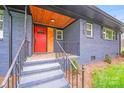Charming home featuring a striking red door, beautiful wood ceiling, and a classic blue brick facade at 2109 Tarlton Dr, Matthews, NC 28105