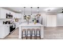 Bright, white kitchen featuring a large center island with seating and modern stainless steel appliances at 2109 Tarlton Dr, Matthews, NC 28105