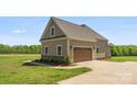 A detached two-car garage echoes the architectural style of the main house with matching siding and stone accents at 244 Alexis Lucia Rd, Alexis, NC 28006