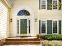 Elegant front entrance with a decorative arched window above the door, flanked by sidelights and sconces at 2906 Crescent Knoll Dr, Matthews, NC 28105