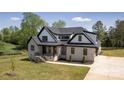 Beautiful two-story home with light brick, black trim, a covered porch, and a manicured lawn at 3500 Manna Ln, Mount Holly, NC 28120