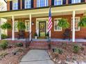 Inviting front porch with rocking chairs, hanging ferns, and an American flag at 5301 Greyfriar Ct, Waxhaw, NC 28173