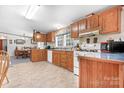 A functional kitchen with wood cabinets, white appliances, and a view into the dining area, creating a cozy cooking space at 6575 Charlotte Hwy, York, SC 29745