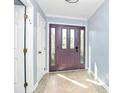Inviting foyer with a purple front door, decorative tile flooring, and neutral paint at 7034 Leaves Ln, Charlotte, NC 28213