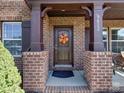 Inviting front entryway with a decorative wreath, brick pillars, and a dark wood door at 9622 Harvest Pond Nw Dr, Concord, NC 28027