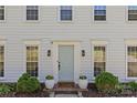 Welcoming front entrance with a light blue door framed by potted plants and elegant lighting fixtures creating curb appeal at 9637 Stoney Hill Ln, Charlotte, NC 28277
