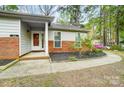 Inviting home entrance with a brick foundation, walkway, and colorful landscaping at 1212 Robinhood Cir, Charlotte, NC 28227