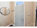 Welcoming entryway featuring a modern door, mirror, and convenient coat hooks for organization at 14130 Misty Brook Ln, Charlotte, NC 28273