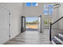 Light-filled home foyer with double doors, a staircase, and large windows with views of the surrounding land at 143 Mills Garden Rd, Statesville, NC 28625