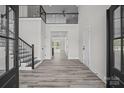Bright open foyer featuring wood flooring, stairs to the upper level, and views through to the back patio at 143 Mills Garden Rd, Statesville, NC 28625