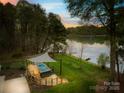 Lush backyard features a deck with a hot tub, fire pit, and easy access to the serene lake at 158 Regency Rd, Mooresville, NC 28117