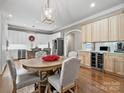 Elegant dining area with hardwood floors, chandelier, and stylish furnishings, complemented by a built-in wine fridge at 1725 Hannon Farm Rd, Fort Mill, SC 29715