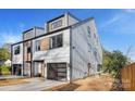 Contemporary home featuring light gray siding, a black framed garage door, and modern design elements at 3129 Rush Ave, Charlotte, NC 28208