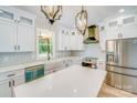 Modern kitchen featuring white cabinetry, stainless steel appliances, and a large island with quartz countertops at 32519 Buchanan Ln, Albemarle, NC 28001