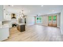 Open-concept living room featuring hardwood floors, large windows, and seamless integration with the kitchen area at 32519 Buchanan Ln, Albemarle, NC 28001