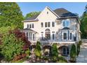 Stunning rear view of the home with a stone facade, large windows, and a spacious balcony overlooking landscaped gardens at 338 Fairfield Ct, Mount Gilead, NC 27306