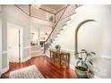Stunning foyer with hardwood floors, a grand staircase, and views into the living room with fireplace at 3409 Pondview Ln, Charlotte, NC 28210