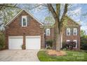 Charming brick home featuring a two-car garage and beautifully mulched landscaping around mature trees at 3409 Pondview Ln, Charlotte, NC 28210