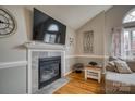 Living room fireplace with stone surround, a TV mounted above, and hardwood flooring at 3704 25Th Street Ne Pl, Hickory, NC 28601