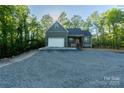 New construction home with a charming facade, attached garage, and a stone driveway lined by tall trees at 472 Oak Rd # 114/115/116, Norwood, NC 28128